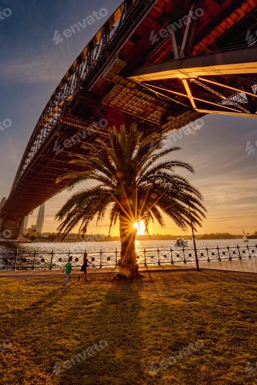 Preview: Bridge crossing a body of water at sunset in Sydney, Australia.