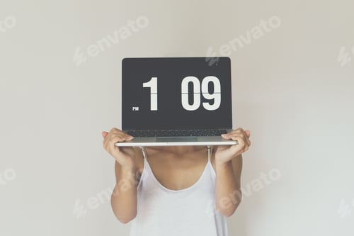 Preview: Woman holding computer with clock front of her face.