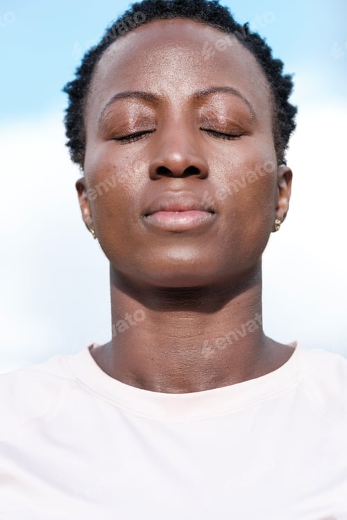 Preview: Head-shot of strong black woman outdoors.