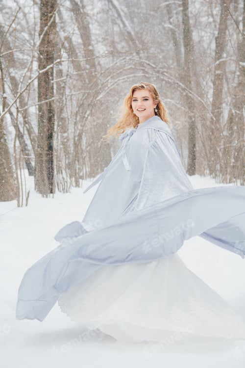 Preview: Young Beautiful Blonde Girl In A Long Skirt Outdoors In The Winter Under The Snowfall. Toning.