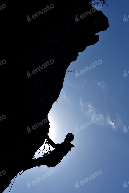 Preview: Silhouette of a rock climber hanging on the wall