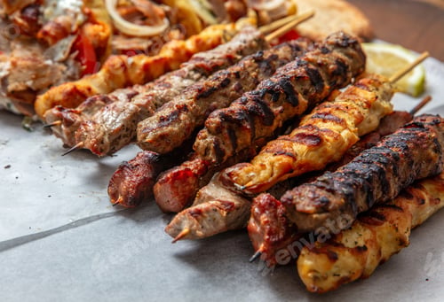 Preview: Mixed grilled meat platter, meat skewers, kebab pieces, and blur gyro wraps background, closeup
