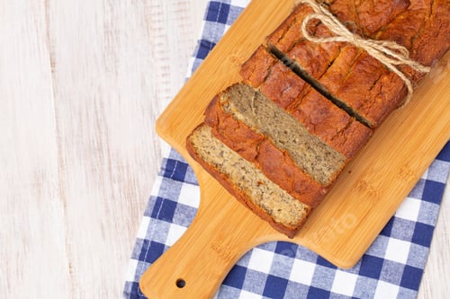 Preview: Banana Bread Breakfast Baked Gluten Free On Wooden Cutting Board With Blue Checked Napkin