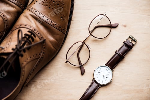 Preview: top view brown shoes, glasses and watch on wooden surface