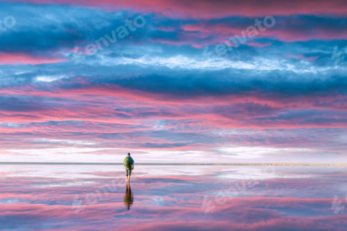 Preview: A tourist stands in calm water