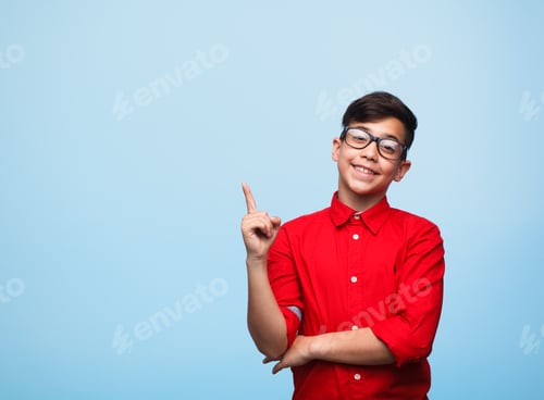 Preview: Smart kid gesturing on blue