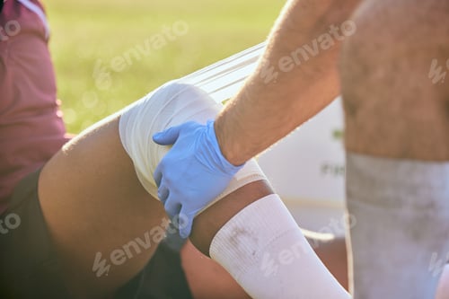 Preview: First aid, sport injury bandage and hands on knee with soccer accident, fitness and massage on a fi