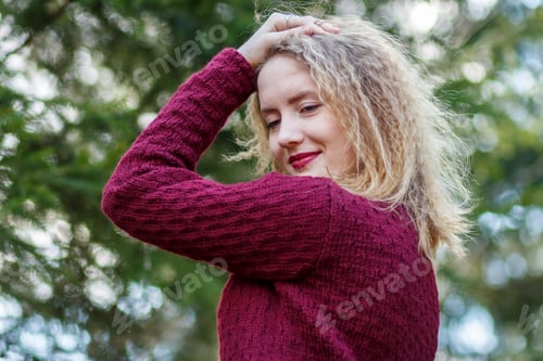 Preview: Blonde Haired Woman in Burgundy Sweater Outdoors