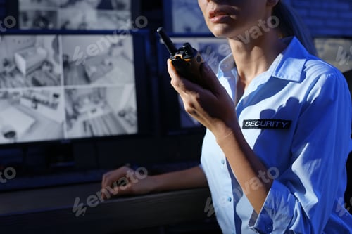 Preview: Female security guard with portable transmitter at workplace, closeup. CCTV surveillance