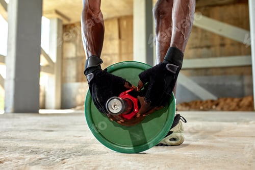 Preview: Athletic black young man lifting a heavy-weight barbell in outdoor gym under the bridge. Healthy