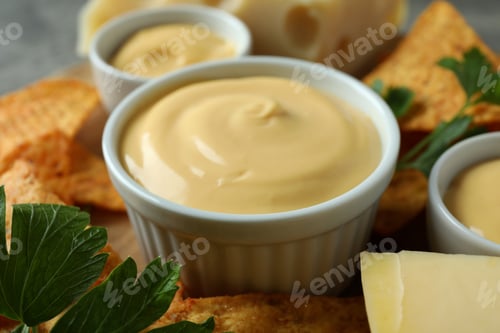 Preview: Concept of snack with chips and cheese sauce, close up