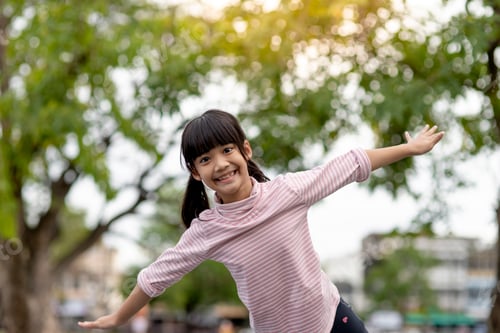 Preview: Asian little girl enjoys playing in a children playground, Outdoor portrait