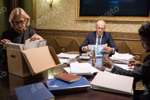 Preview: Three contemporary lawyers working with papers by table