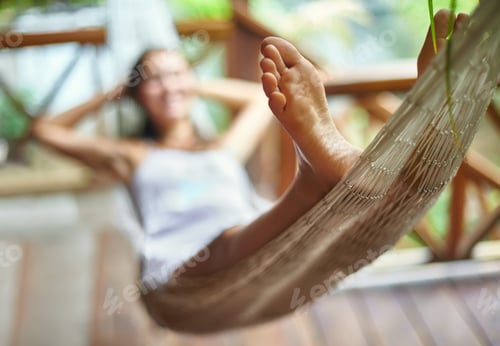 Preview: Young woman relaxing in hammock in a tropical resort. Focus on foot