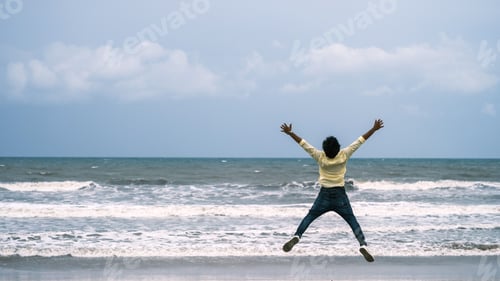 Preview: Closeup of a black woman jumping happily on the sea coast having fun