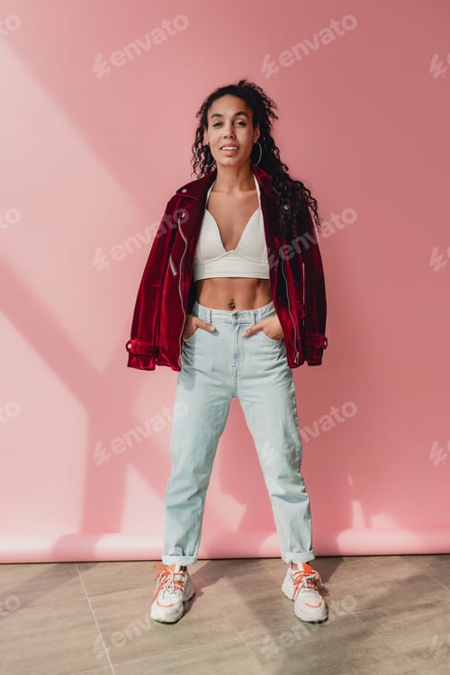Preview: attractive black african american woman in stylish outfit on pink background