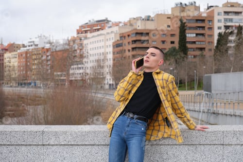 Preview: Young non binary person speaking on a smartphone with the eyes closed. Make up androgynous person.