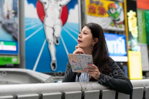 Preview: girl using map on bridge near glico man sign