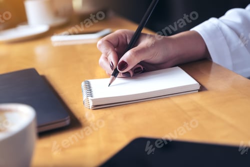 Preview: woman's hand writing on a blank notebook