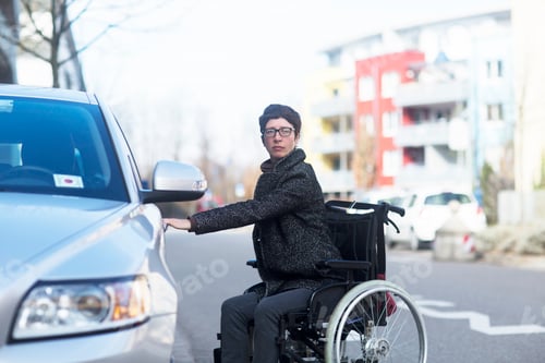 Preview: Woman in wheelchair, opening car door