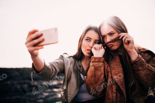 Preview: Young Girls taking selfie with smartphone pulling faces