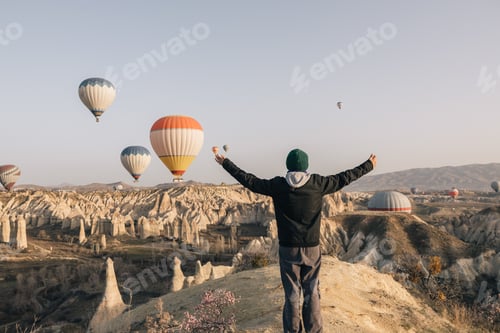 Preview: Teenage girl opening her arms in front of a mountain of stones