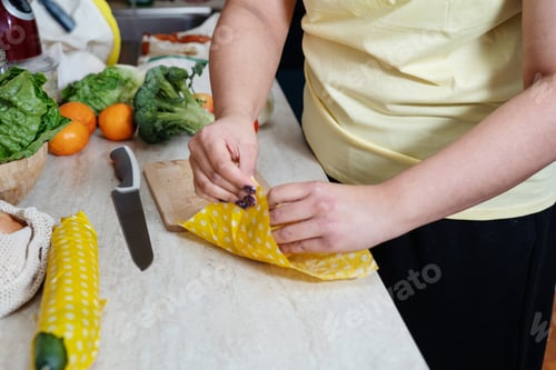 Preview: Unrecognisable woman wrapping cucmber in beeswax cloth