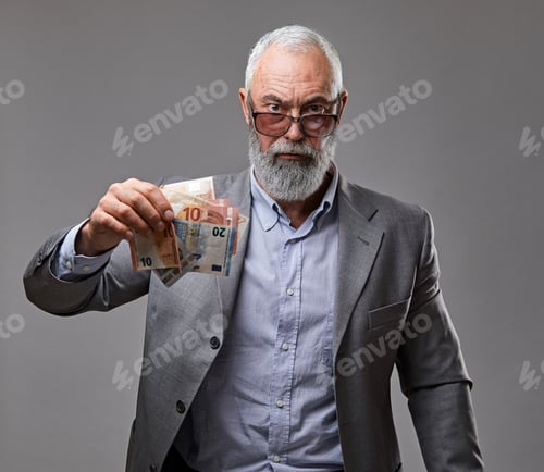 Preview: Rich elderly business person dressed in suit holding money
