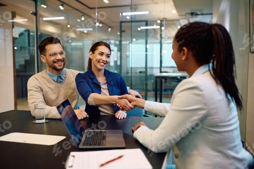 Preview: Happy couple greeting their financial advisor in the office.