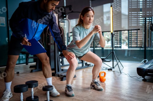 Preview: Asian man and woman working out, one is a trainer, the other is an exerciser