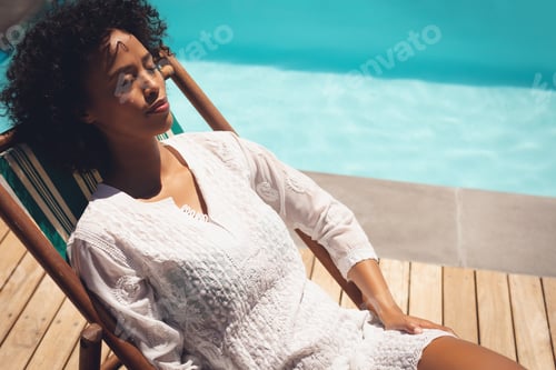 Preview: Close-up of African American woman relaxing on sun lounger in her backyard on a sunny day