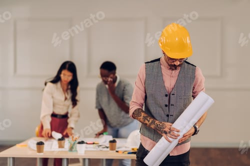 Preview: Male architect using blueprint and tablet in an office during a meeting