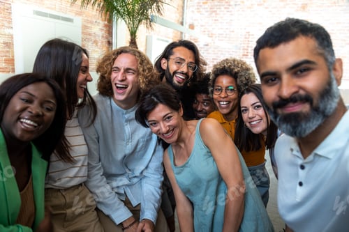 Preview: Happy multiracial group of coworkers take selfie together in the office.
