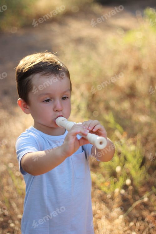 Preview: Summer, a boy in a clearing playing the flute.