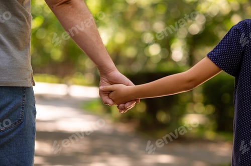 Preview: the father's hand held tightly the hand of his little son