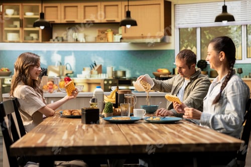 Preview: Family serving breakfast in the kitchen and pouring orange juice