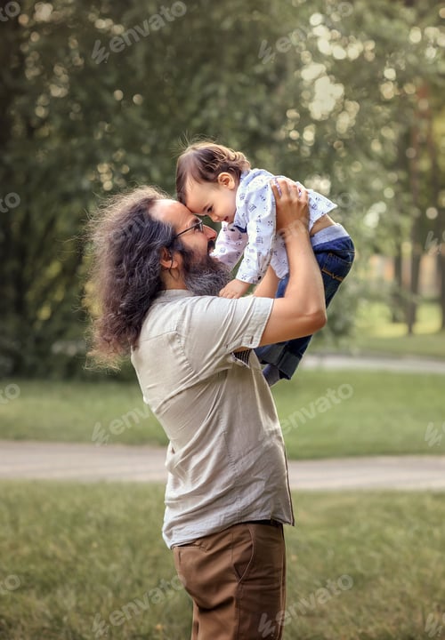 Preview: Happy father tickling laughing adorable son close up, family having fun at nature, smiling dad holdi