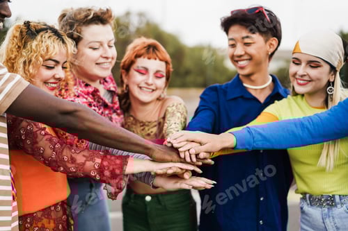 Preview: Young diverse people celebrating together stacking hands outdoor - Focus on hands