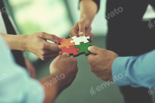 Preview: Group of business people assembling jigsaw puzzle