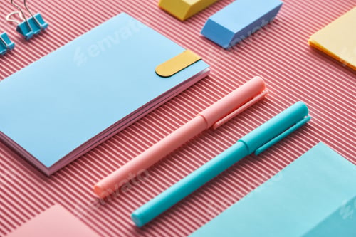 Preview: colorful pens, notebooks and erasers on pink