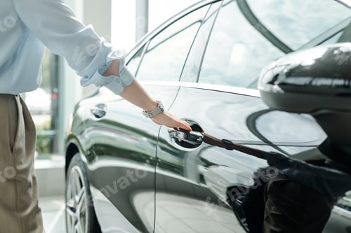 Preview: Hand of young elegant man in shirt and trousers going to open the door of car