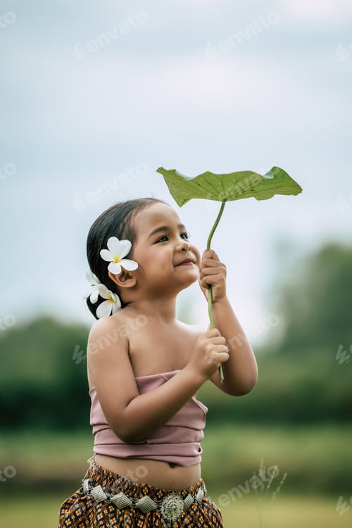 Preview: Cute girls in Thai traditional dress holding leaf of lotus