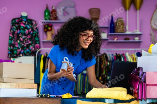 Preview: Beautiful young hispanic woman managing her home e-commerce business from home