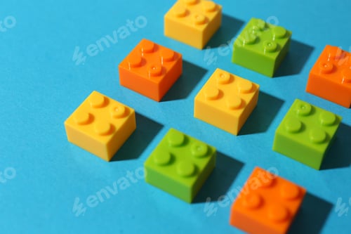 Preview: Construction toy. Colorful building bricks on light blue background, closeup