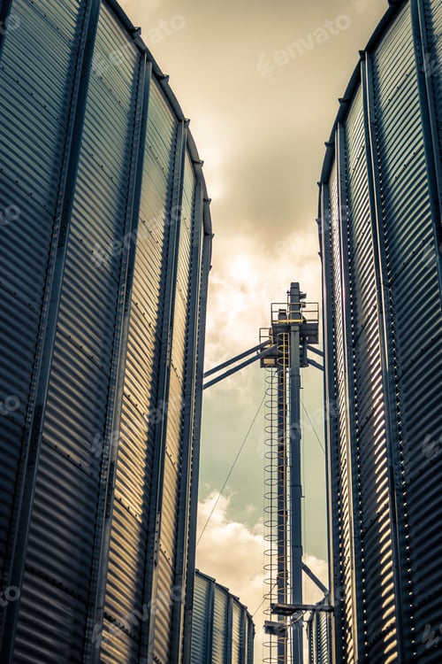 Preview: Closeup view of grain storage silos against a cloudy sky