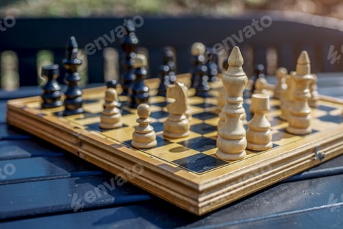 Preview: Closeup shot of the chessboard with chess pieces on blurred background under a sunlight