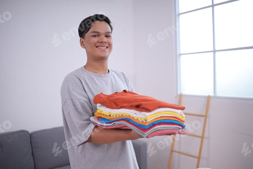 Preview: Person Holding a Stack of Clean Clothes