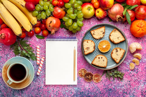 Preview: top view fresh fruit composition colorful fruits with sliced cakes and cup of tea on pink desk