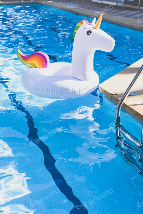 Preview: Inflatable colorful white unicorn at the swimming pool. Vacation time in the swim pool with toys