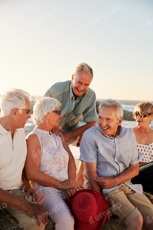 Preview: Group Of Senior Friends Sitting On Rocks By Sea On Summer Group Vacation